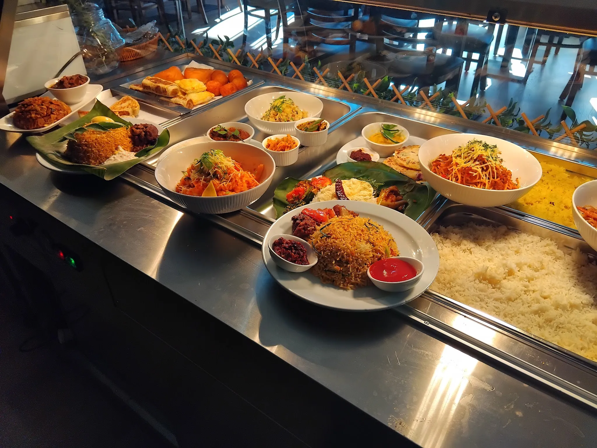 Sri Lankan buffet spread of rice, curries and short eats on a serving counter