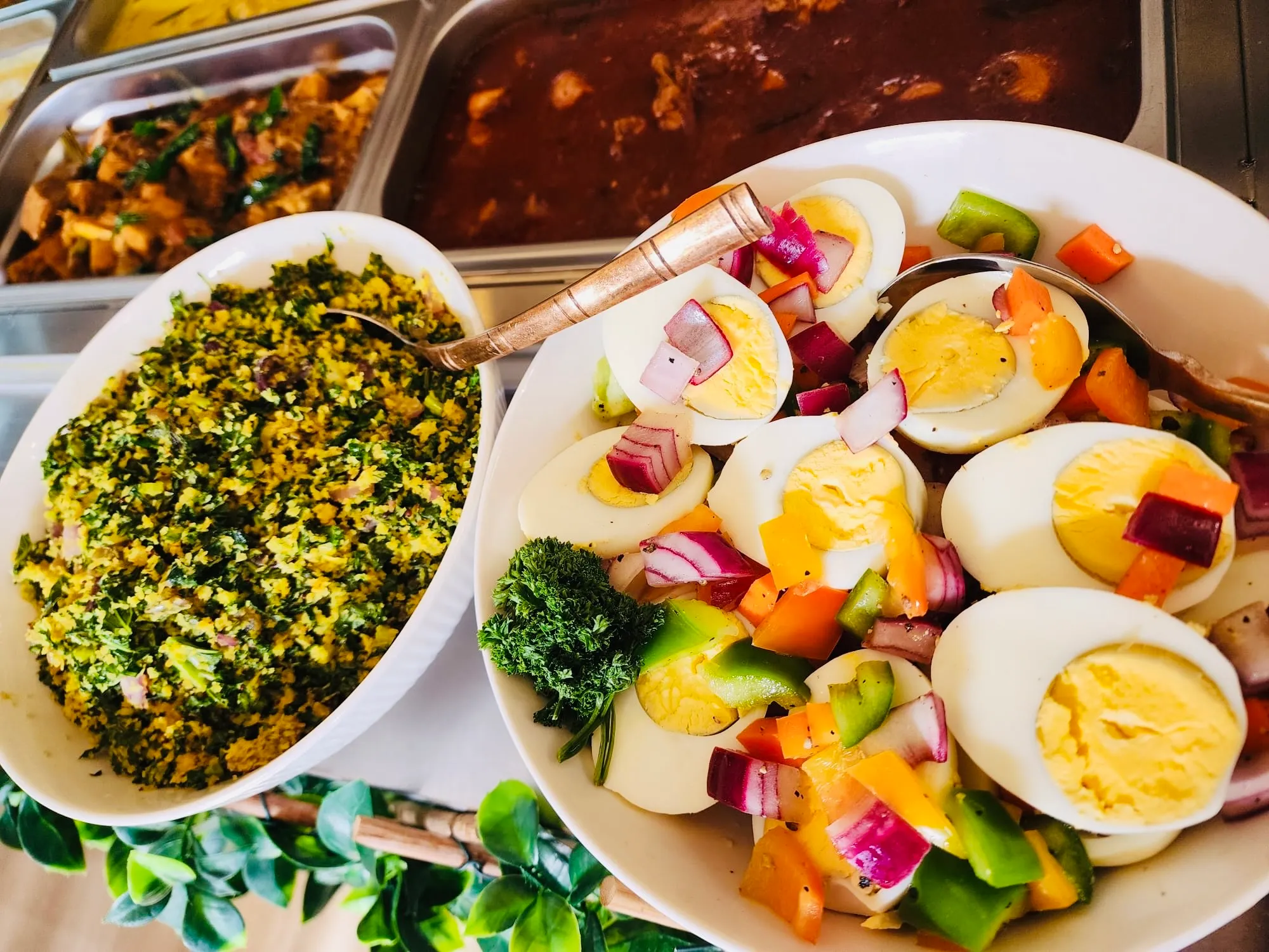 Buffet bowls of green mallum and egg-and-vegetable salad seen from above