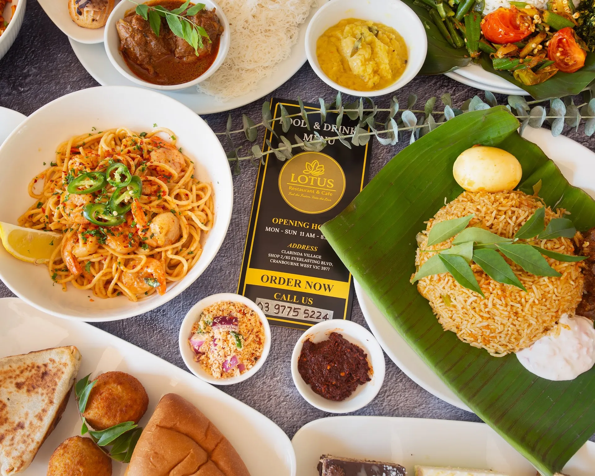 Overhead Sri Lankan food spread around a Lotus menu card with biryani and noodles